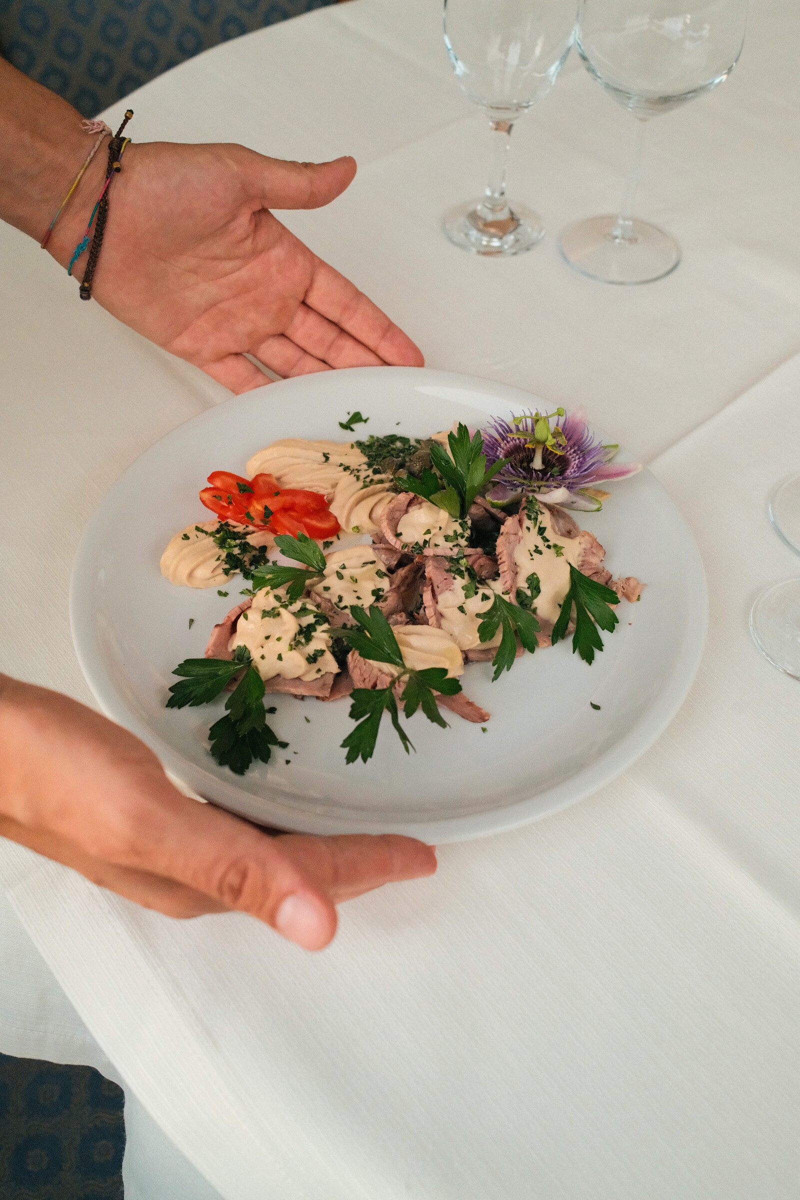 Piatto servito in tavola con calici di vino